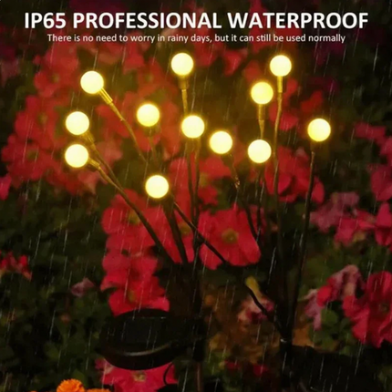 Eldflugor på solceller för trädgården, svänger i vinden.