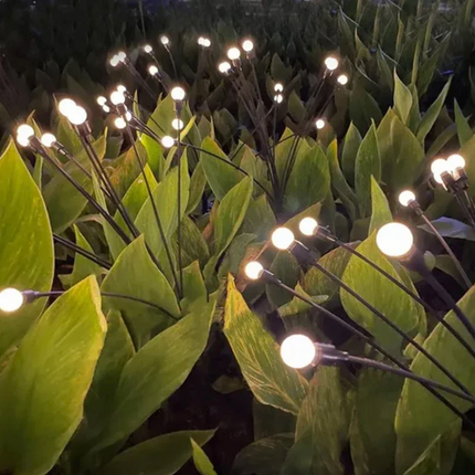 Eldflugor på solceller för trädgården, svänger i vinden.